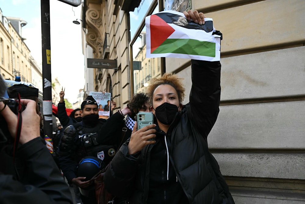 A protester is escorted away by French police forces who dismantled a pro-Palestine sit-in at the Institute of Political Studies (Sciences Po Paris) in Paris on Friday, May 3, 2024. (AFP)