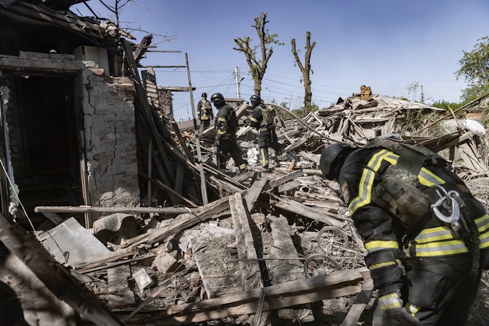 Firefighters inspect debris of a building hit by shelling in Kharkiv, Ukraine, Friday, May 3, 2024. (AP Photo/Yevhen Titov)