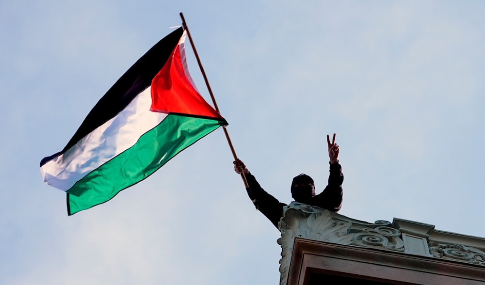 A student protester waves a Palestinian flag above Hamilton Hall on the campus of Columbia University, Tuesday, April 30, 2024, in New York, US. (AP)