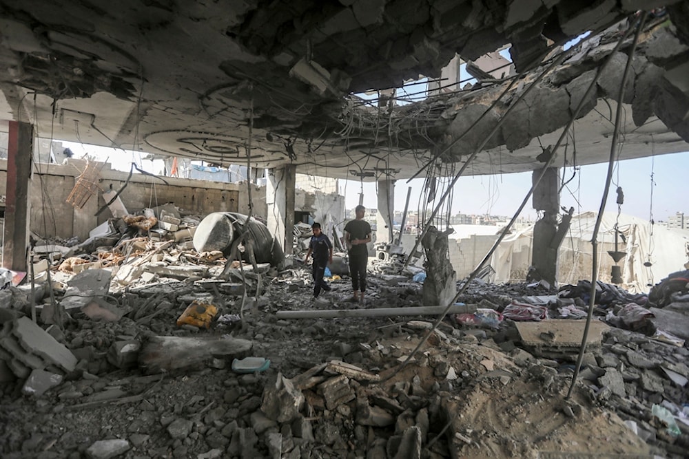 Palestinians stand in the ruins of the Chahine family home, after an overnight Israeli strike in Rafah, southern Gaza Strip, Friday, May 3, 2024 (AP)