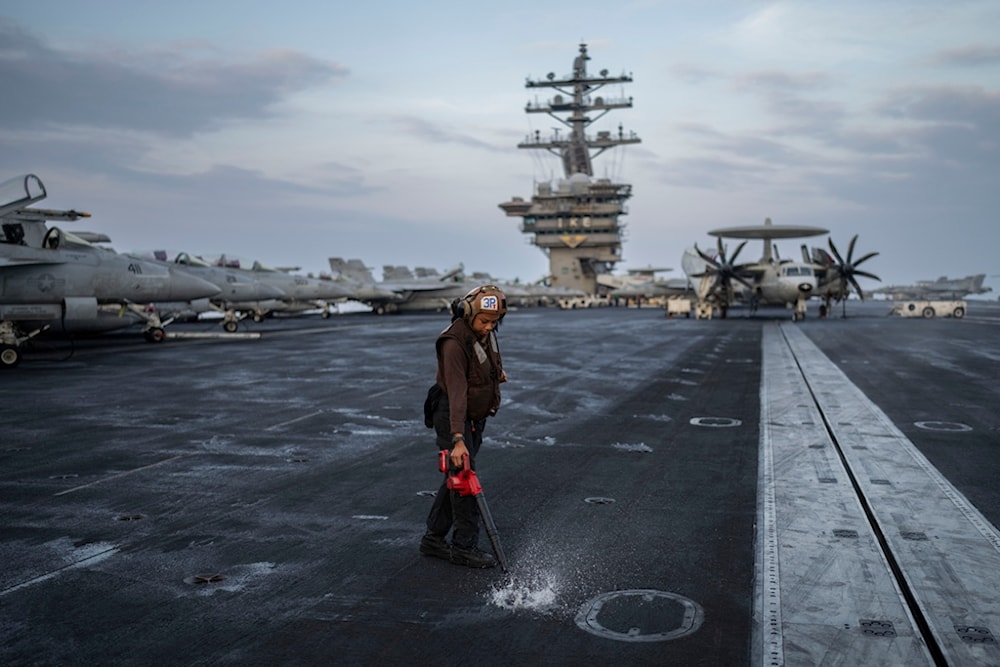 A crew member does maintenance work on the deck of the U.S.S. aircraft carrier Dwight D. Eisenhower, also known as the 'IKE', on the south Red Sea, Tuesday, Feb. 13, 2024. (AP)