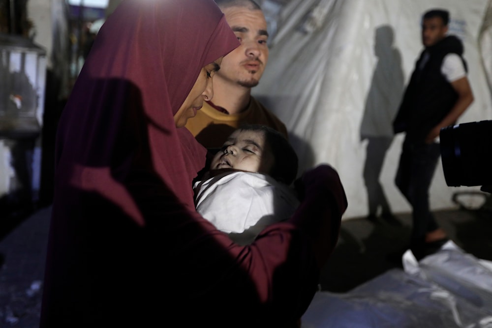 A Palestinian woman mourns her relative, 7-month-old baby Hani Qeshta, who was killed in an Israeli bombardment on a residential building in Rafah, southern Gaza Strip, occupied Palestine, May 5, 2024 (AP)