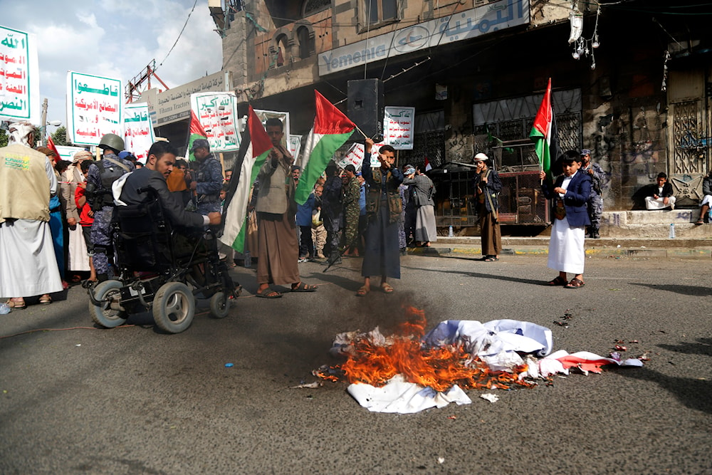 Protesters burn representation of the US and Israeli flags in Sanaa, Yemen, July 4, 2023 (AP)
