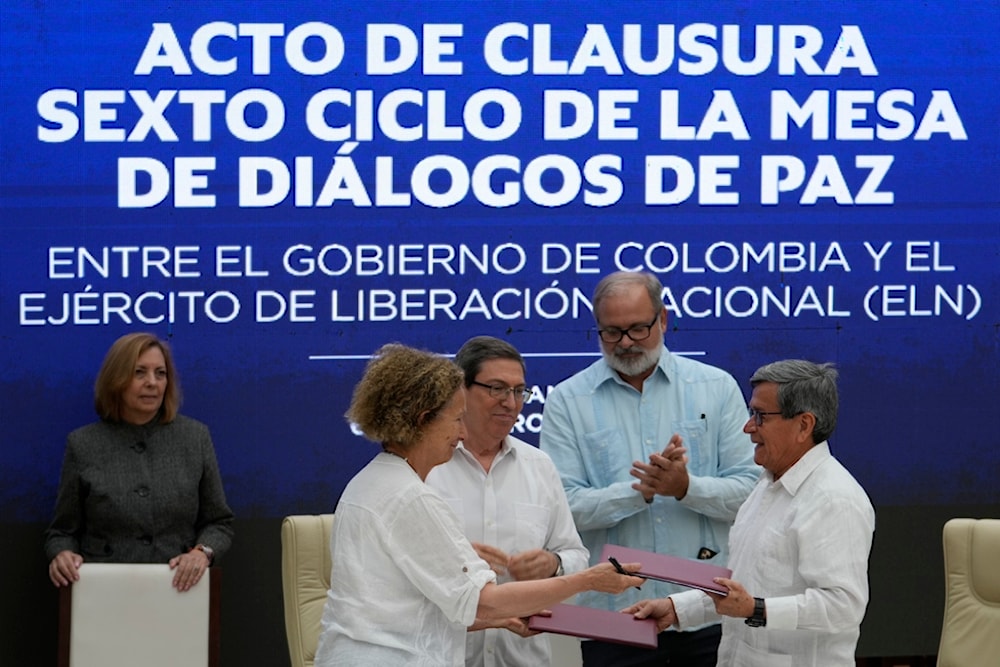 Colombian government rep. Vera Grabe and commander of the National Liberation Army (ELN) Pablo Beltran, exchange their signed ceasefire extension agreement in Havana, Cuba, Feb. 6, 2024. (AP)