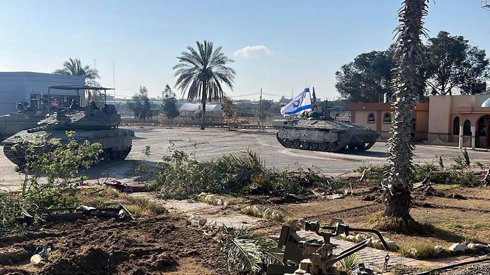 This photo shows a tank with an Israeli occupation flag on it entering the Gazan side of the Rafah border crossing in occupied Palestine, on Tuesday, May 7, 2024. (AP)