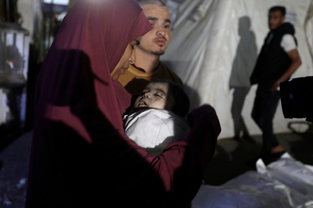 A Palestinian woman mourns 7-month-old baby Hani Qeshta, who was killed in an Israeli bombardment on a residential building with Qeshta's family, in Rafah, southern Gaza Strip, Sunday, May 5, 2024. (AP)