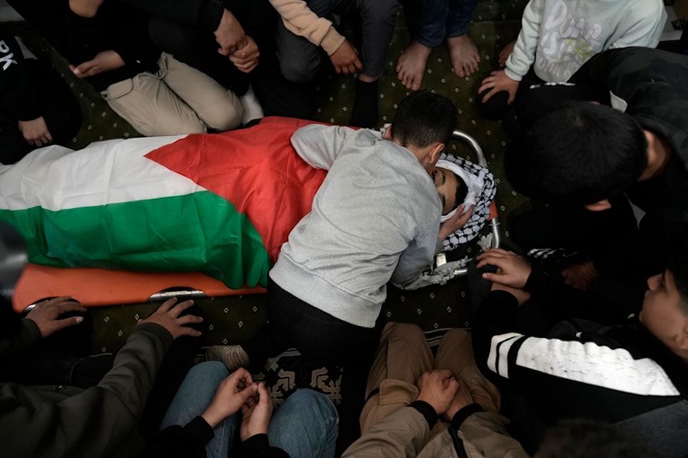Mourners gather around the body of Mutasim Abu Abed, 13, during his funeral in Qabatiya, near the West Bank city of Jenin, Saturday, March 30, 2024 (AP Photo/Majdi Mohammed)
