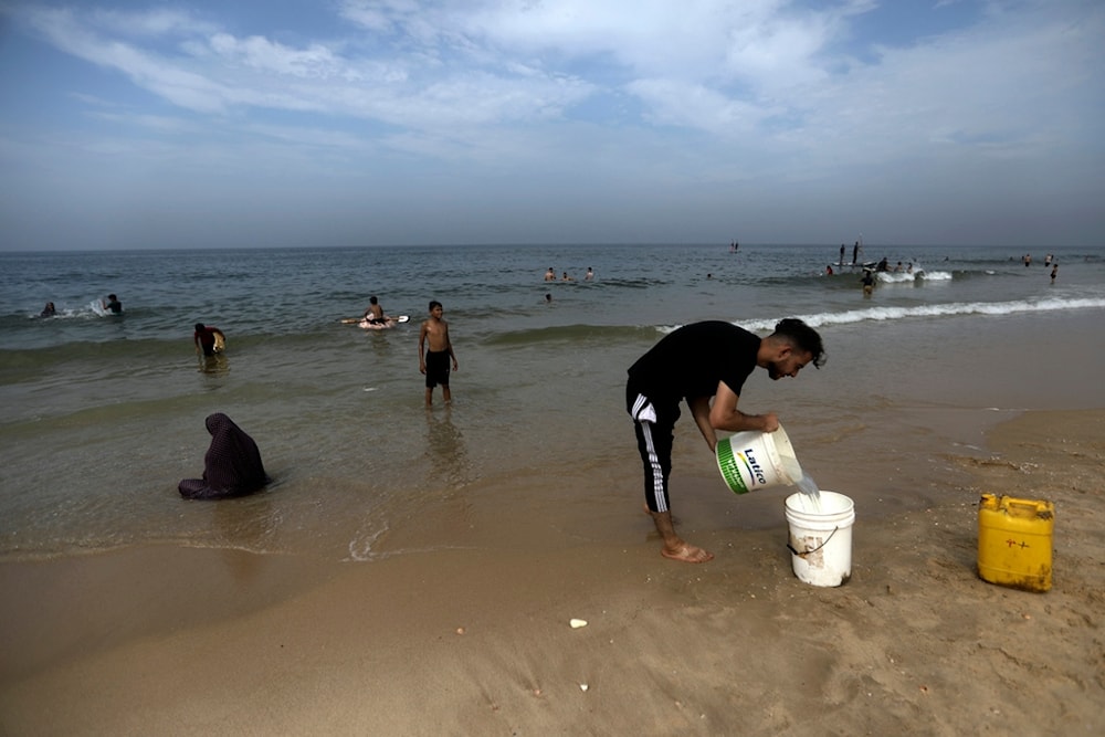 Palestinians resort to the seawater to bathe and clean their tools and clothes due to the continuing water shortage in the Gaza Strip, on the beach of Deir al-Balah, Central Gaza Strip, Sunday, Oct. 29, 2023. (AP)