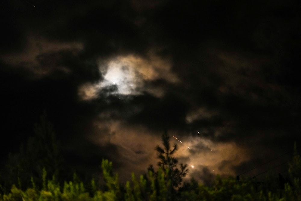 Projectiles fly through the sky in central occupied Palestine as a siren sounds a warning of incoming missiles fired from Iran towards the Israeli occupation, Tuesday, October 1, 2024 (AP)