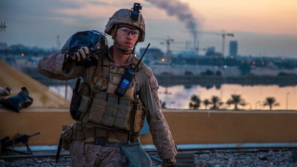 In this Saturday, Jan. 4, 2020, photo, a US Marine carries a sand bag during the reinforcement of the US embassy compound in Baghdad, Iraq. (AP)