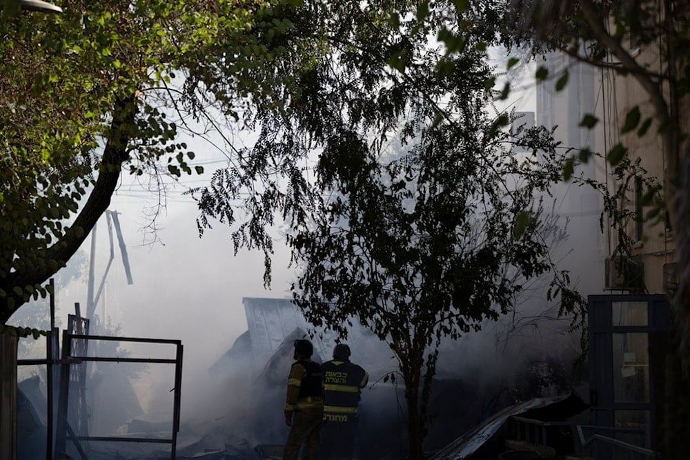 Firefighters work to extinguish a fire after a rocket, fired from Lebanon, hit the Israeli settlement of Kiryat Shmona, northern occupied Palestine, Wednesday, October 9, 2024 (AP)