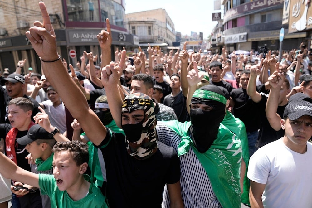 Palestinians wear Hamas scarves and headbands as they protest the assassination of Hamas top leader Ismail Haniyeh, in the West Bank city of Nablus, Wednesday, July 31, 2024 (AP)