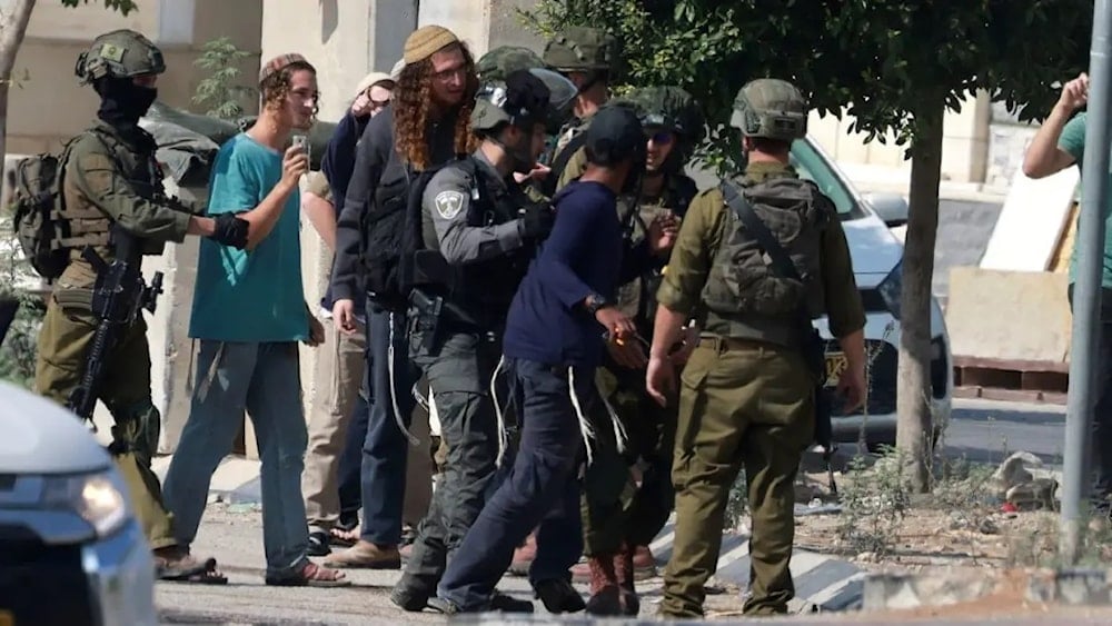 Israeli soldiers restrain Jewish settlers after they stormed the Palestinian West Bank village of Dayr Sharaf. (AFP)