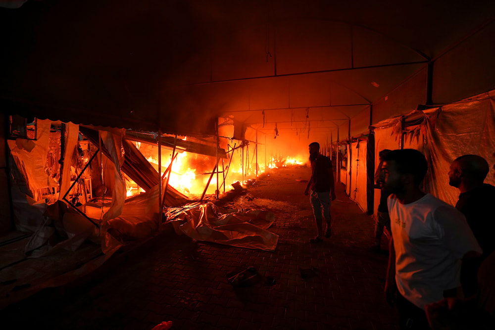 Palestinians react to a fire after an Israeli strike hit a tent area in the courtyard of Al Aqsa Martyrs hospital in Deir al Balah, Gaza Strip, on October 14, 2024. (AP)