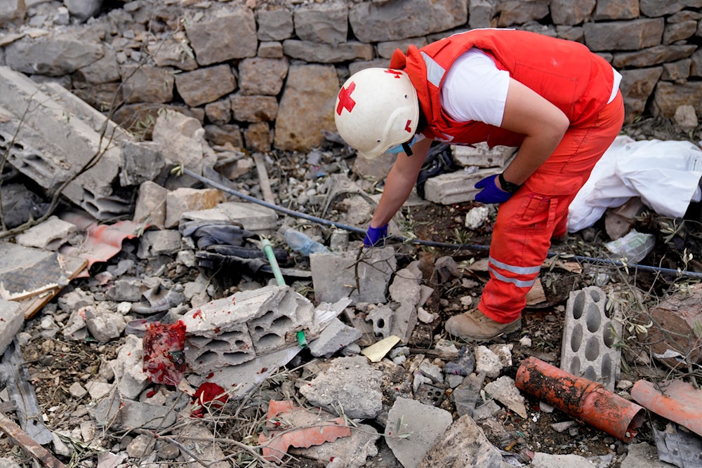 A Lebanese Red Cross volunteer searches for body remains between the rubble of a destroyed building at the site of Monday's Israeli airstrike in Aito village, north Lebanon, Tuesday, Oct. 15, 2024.(AP)