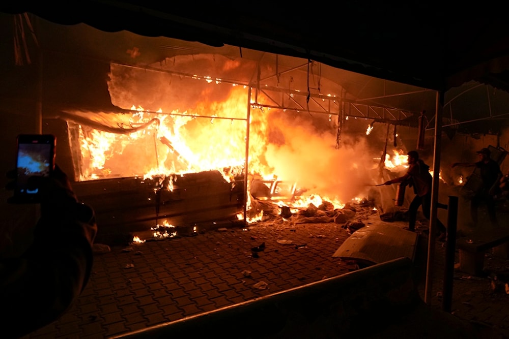 Palestinians try to extinguish fire caused by an Israeli strike that hit a tent area in the courtyard of Al Aqsa Martyrs hospital in Deir al-Balah, Gaza Strip, Monday, Oct. 14, 2024. (AP)