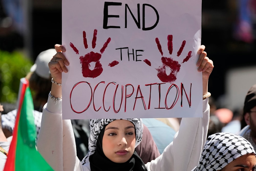 A woman holds a sign as people gather in central Sydney for a rally Sunday, Oct. 15, 2023, to support Palestinians in Gaza (AP)