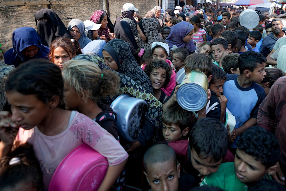 Palestinians line up for food distribution in Deir al-Balah, Gaza Strip, October 17, 2024. (AP)