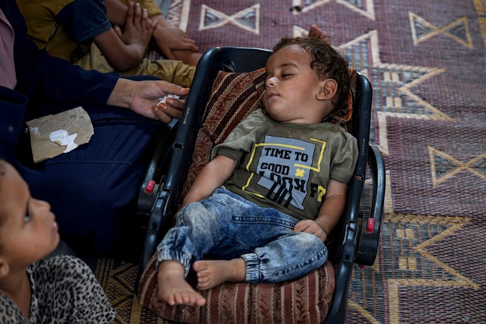 Displaced infant Abdel-Rahman Abu El-Jedian, who suffers from polio, sleeps at a makeshift tent camp in Deir al-Balah, central Gaza Strip, on August 27, 2024. (AP)