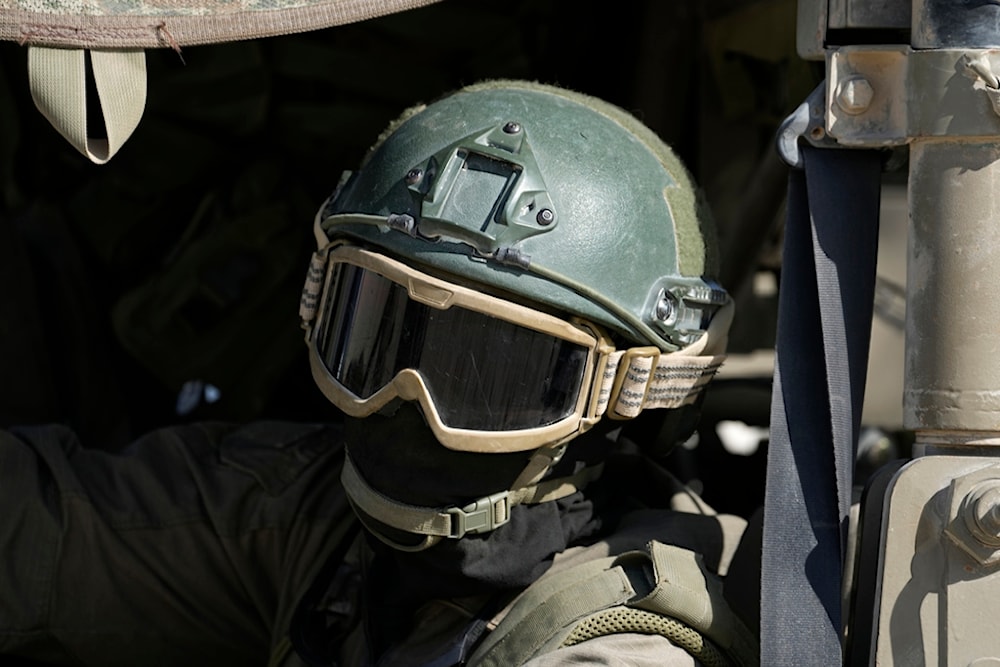 An Israeli soldier drives in a vehicle on the separation line with Gaza, as seen from southern occupied Palestine, Friday, Oct. 18, 2024. (AP Photo/Tsafrir Abayov)