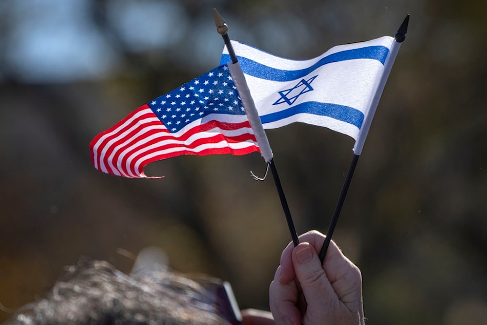 A participant holds miniature US.and Israeli flags as they stand on the National Mall at the March for 