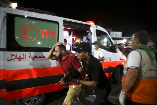  Palestinian medics help a man wounded in Israeli strikes in Gaza City on Oct. 13, 2023. (AP)