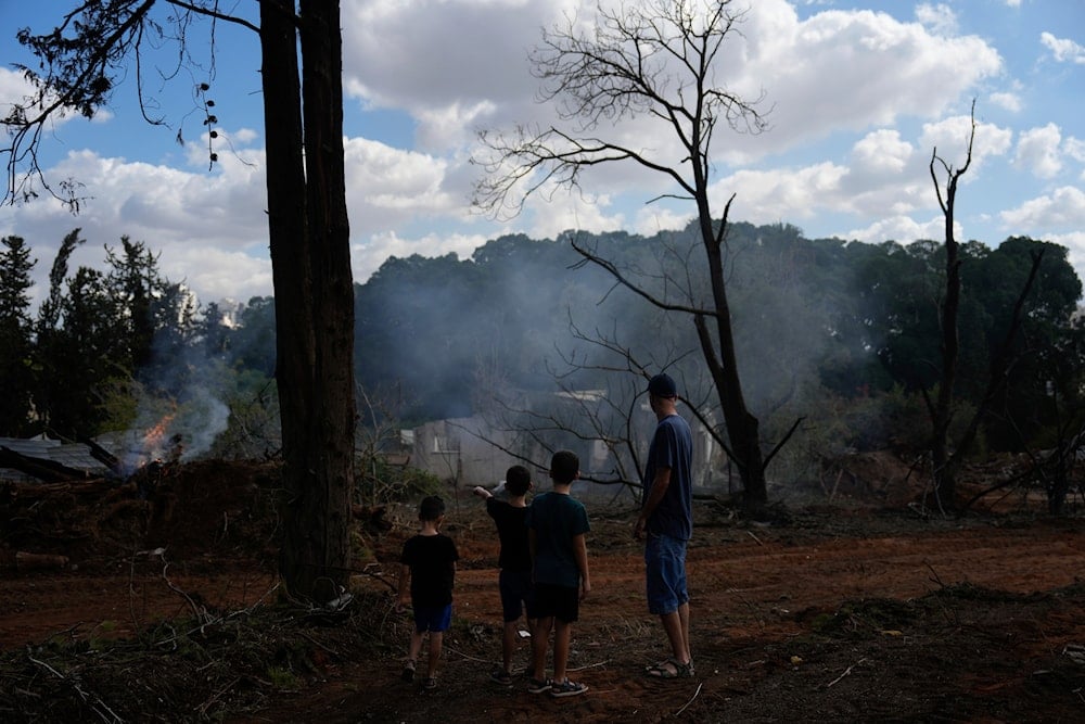 People look at a destroyed building that was hit in Iran's Operation True Promise 2 operation in Hod Hasharon, occupied Palestine on  October 2, 2024. (AP)