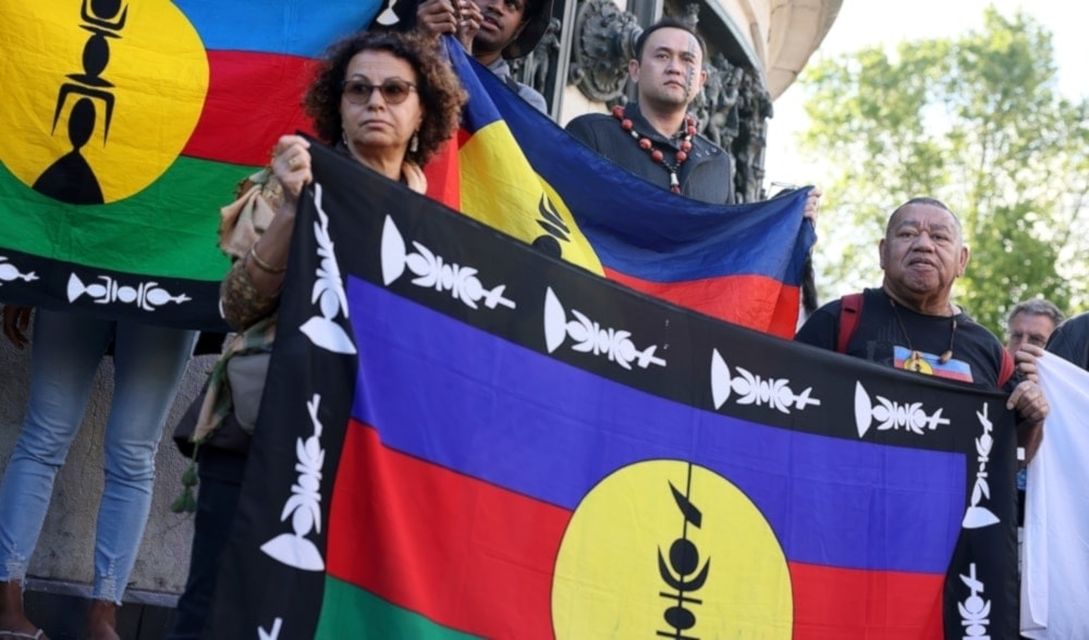 Demonstrators hold Kanak and Socialist National Liberation Front (FLNKS) flags during a gathering in Paris, on May 16,2024. (AP)