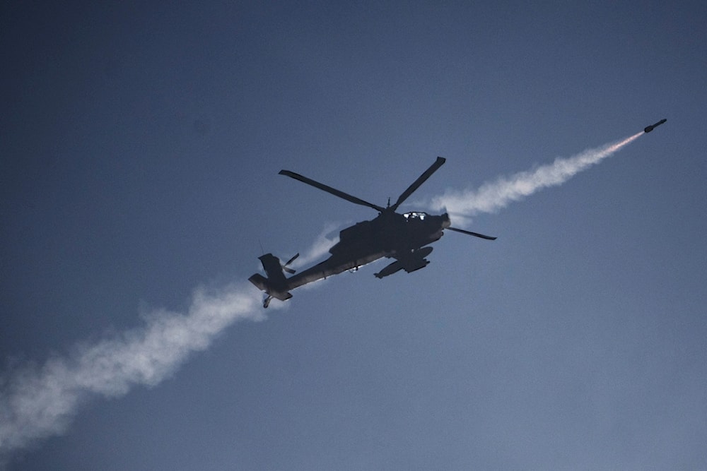 An Israeli Apache helicopter fires a missile towards southern Lebanon as seen from northern occupied Palestine, Sunday, October 13, 2024 (AP)