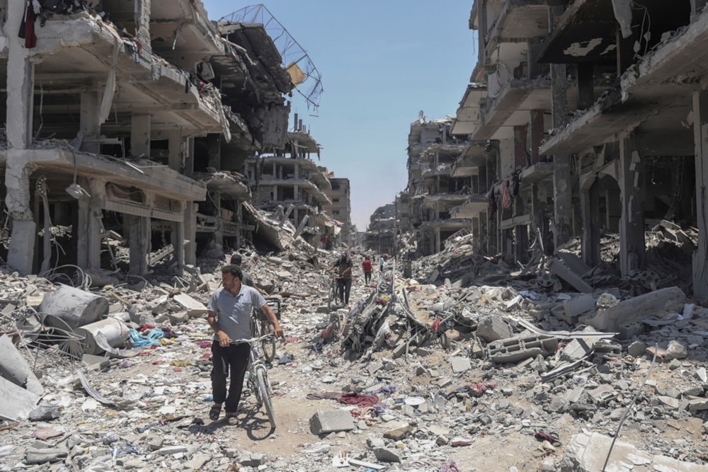 Palestinians walk through the destruction in the wake of an Israeli air and ground offensive in Jabaliya, northern Gaza Strip, May 30, 2024. (AP)