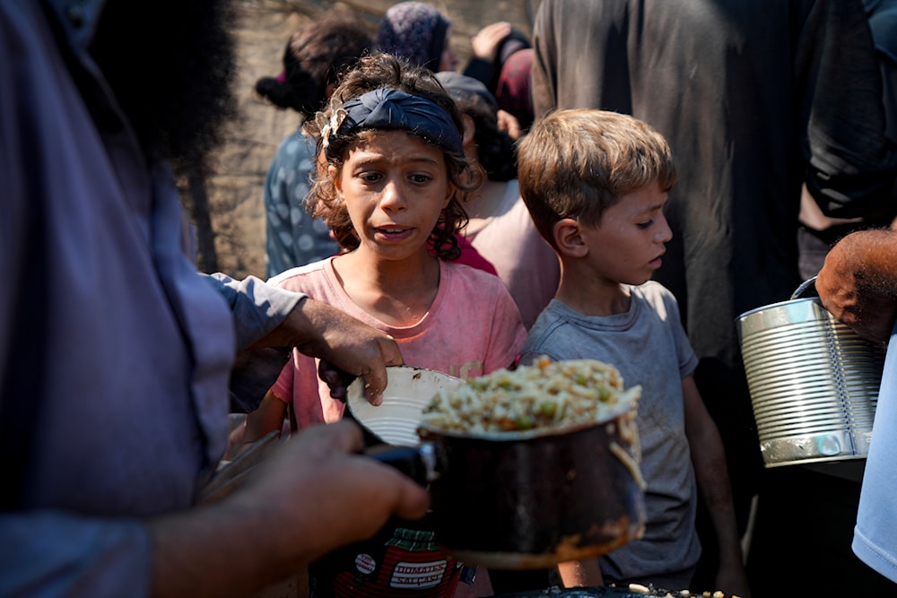 Palestinians line up for food distribution in Deir al-Balah, Gaza Strip, October 17, 2024. (AP)