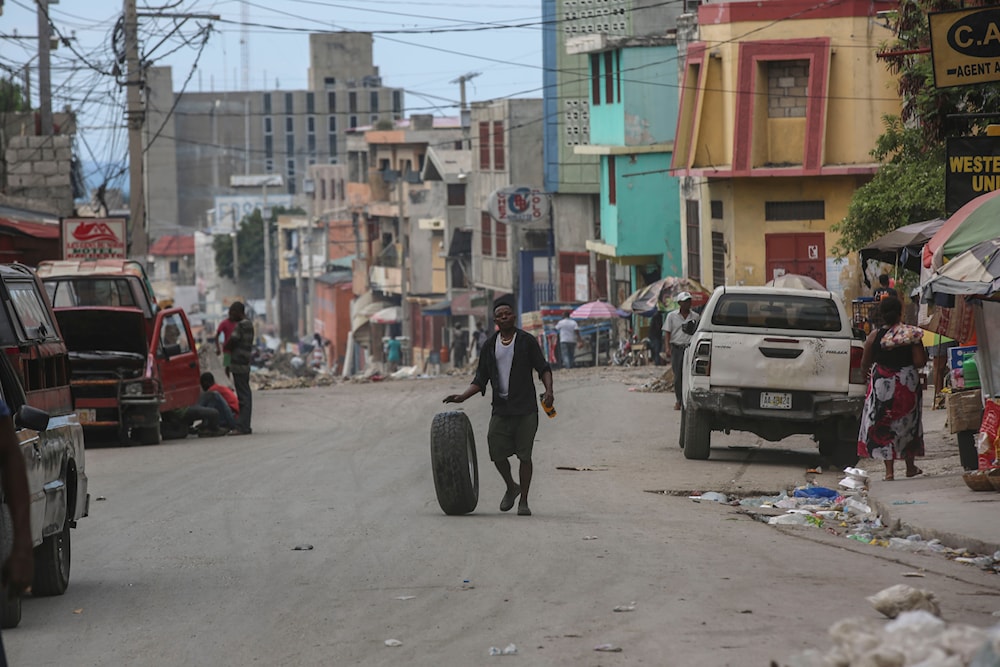 A man rolls a tire as walks along a street in Port-au-Prince, Haiti, on October 17, 2024. (AP)