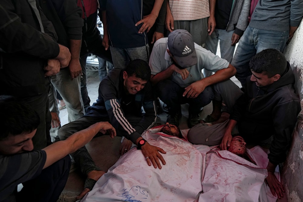 Palestinians mourn their relatives killed in the Israeli bombardment of the Gaza Strip at a hospital in Deir el-Balah, Sunday, Oct. 20, 2024. (AP)