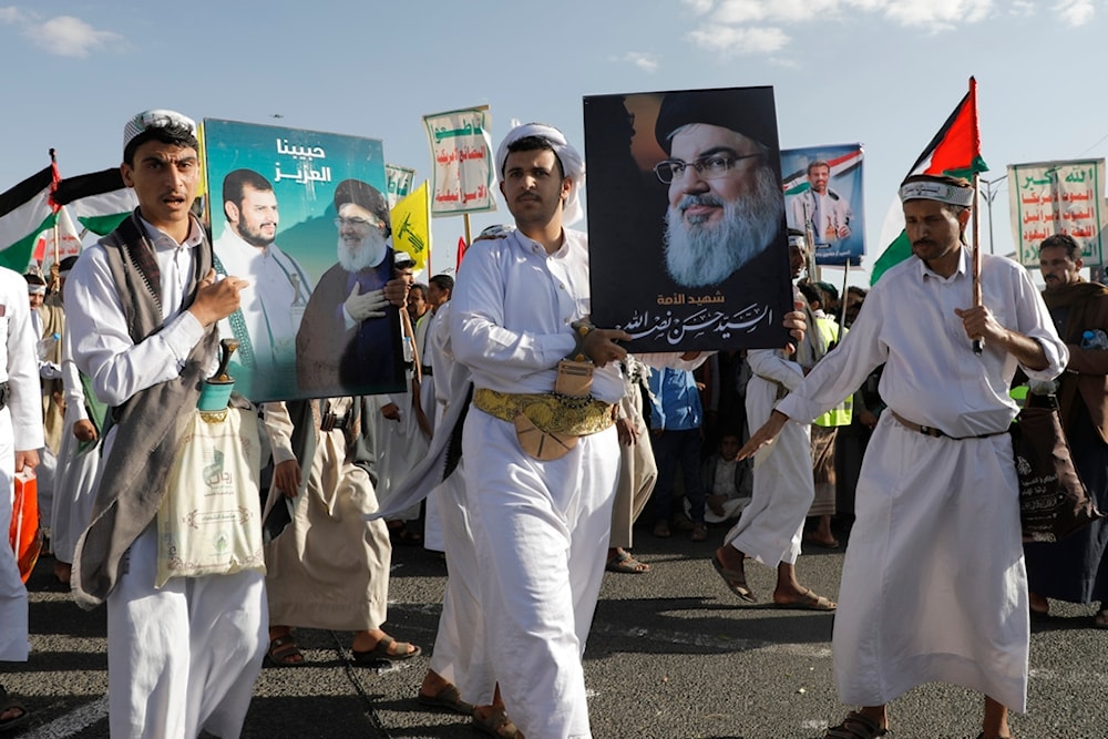 Houthi supporters raise a poster of martyred Hezbollah leader Sayyed Hassan Nasrallah during a rally to commemorate the one-year anniversary of the war on Gaza, in Sanaa, Yemen, Monday, October 7, 2024 (AP)