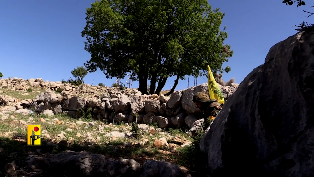 A Hezbollah fighter bears the flag of the Islamic Resistance movement in an undisclosed location, possibly in southern Lebanon (Undated/Islamic Resistance in Lebanon Military Media)