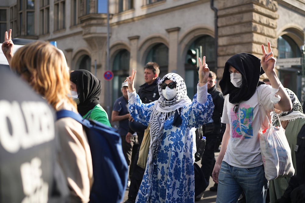 Pro-Palestinians demonstrators who show the victory sign are escorted by police as they leave a building of the Humboldt University in Berlin, Germany, on May 23, 2024. (AP)