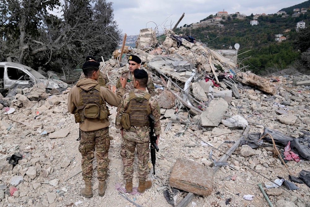 Lebanese army soldiers stand on the rubble of a destroyed building at the site of Monday's Israeli airstrike in Aito village, north Lebanon, Tuesday, Oct. 15, 2024. (AP)