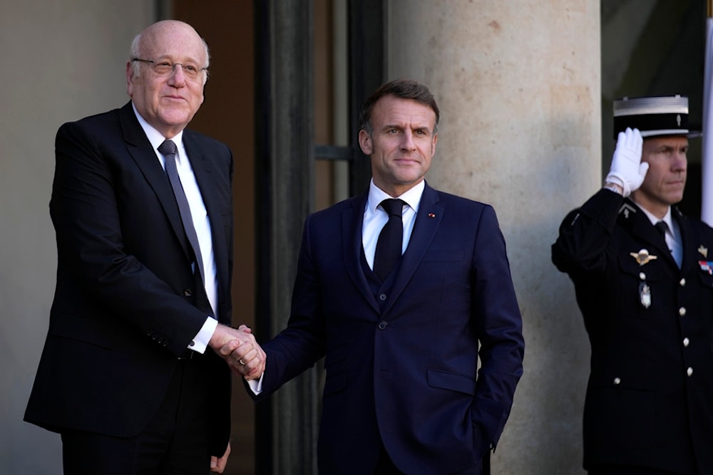 French President Emmanuel Macron welcomes Lebanese caretaker Prime Minister Najib Mikati, left, Wednesday, Oct. 23, 2024 at the Elysee Palace in Paris. (AP Photo/Louise Delmotte)