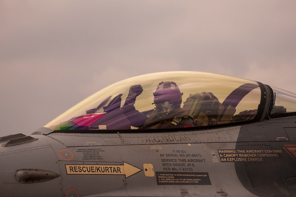 A Turkish Air Force pilot gestures from the cockpit of an F-16 military fighter jet before an Air Policing exercise at the Baza 86 military air base, outside Fetesti, Romania, Wednesday, March 6, 2024 (AP)