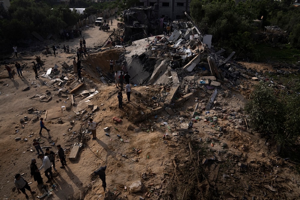 Palestinians inspect the rubble of a house after it was struck by an Israeli airstrike in Beit Lahia, northern Gaza Strip, Friday, May 12, 2023. (AP)