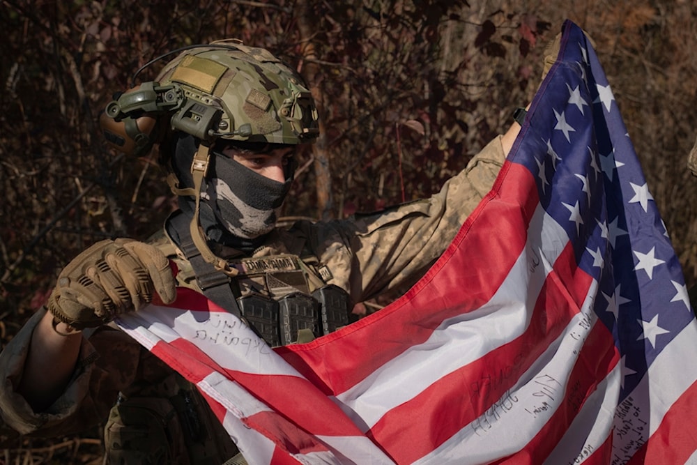 A US mercenary who serves with the 23rd separate rifle battalion of Ukraine's Armed Forces, holds the US flag near the front line in the Kharkov region, Ukraine, Saturday, Oct. 26, 2024. (AP)