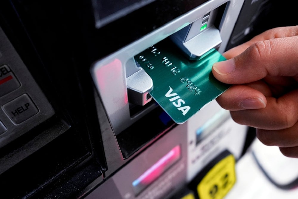 A customer uses a Visa credit card to pay for gasoline at a gas station in Mundelein, Ill., Feb. 8, 2024. (AP)