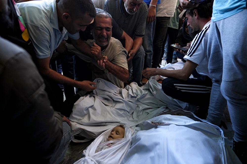 Palestinians mourn for relatives killed in the Israeli bombardment of the Gaza Strip at a hospital morgue in Deir al-Balah, Wednesday, Oct. 2, 2024. (AP)