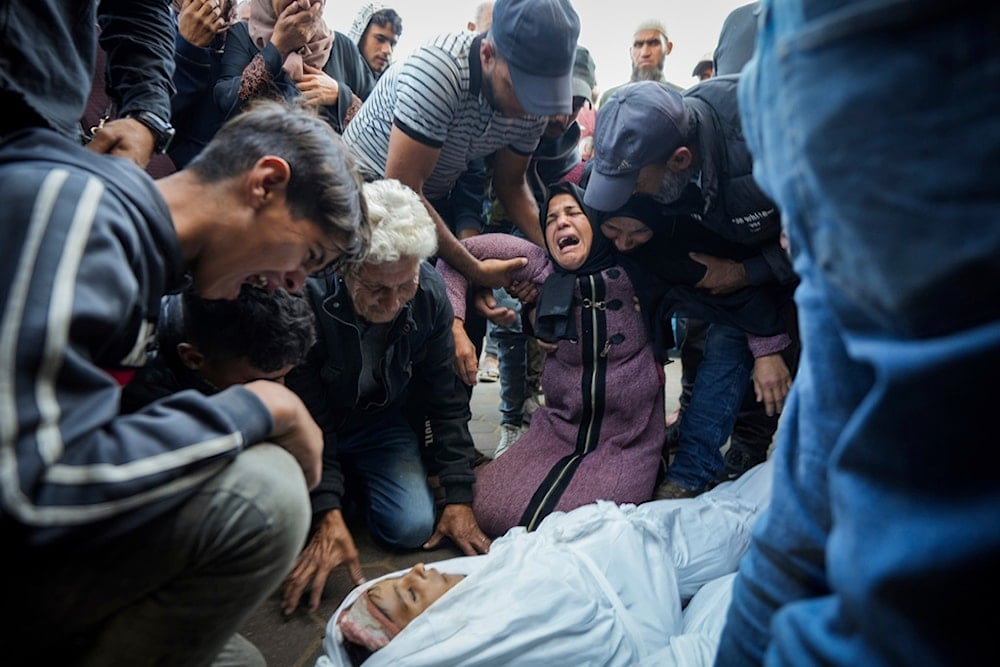 Palestinians mourn their relatives killed in the Israeli bombardment of the Gaza Strip at a hospital morgue in Deir al-Balah, Tuesday, October 29, 2024 (AP)