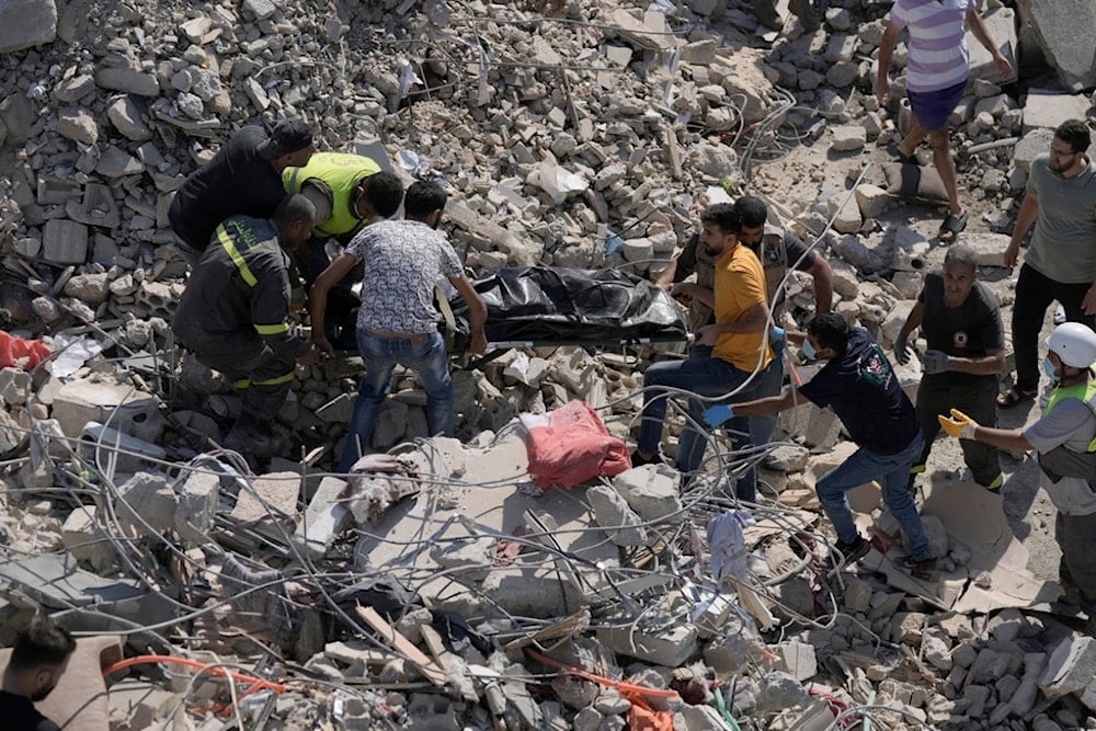 Rescue workers carry the body of a victim found under the rubble of a destroyed building that was hit Tuesday night in an Israeli airstrike, in Sarafand, south Lebanon, Wednesday, Oct. 30, 2024. (AP)