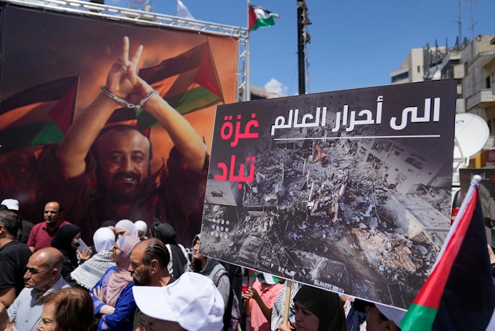 A protester holds a sign reading, 