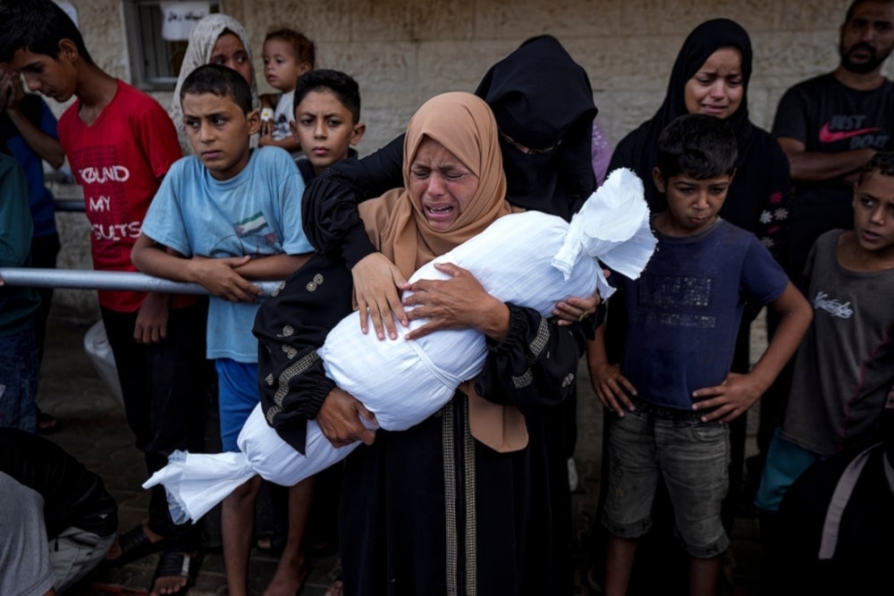 A Palestinian mother mourns her little child killed in the Israeli bombardment of the Gaza Strip, at a hospital in Deir al-Balah, on October 1, 2024. (AP)