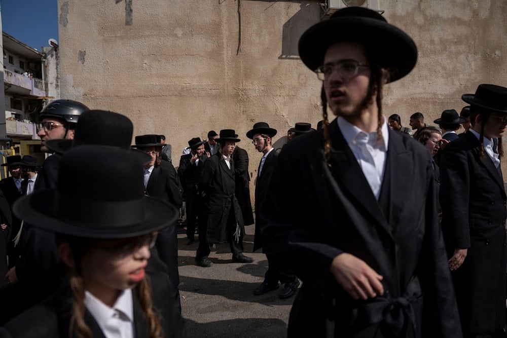 Ultra-Orthodox Jewish men attend a protest against a potential new draft law which could end their exemptions from military service in occupied al-Quds, October 31, 2024. (AP)