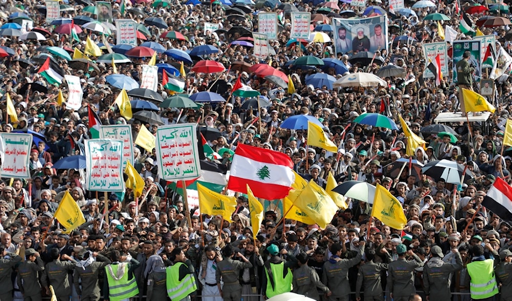 Yemeni supporters raise flags and signs during an anti-Israel and anti-US rally in Sanaa, Yemen, Friday, Sept. 27, 2024. Arabic reads, 'death to Israel and America'. (AP)