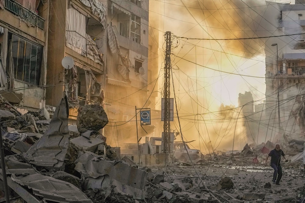 A man runs for cover as a smoke raises in the background following an Israeli airstrike in Dahiyeh, Beirut, Lebanon, Friday, Oct. 4, 2024. (AP)